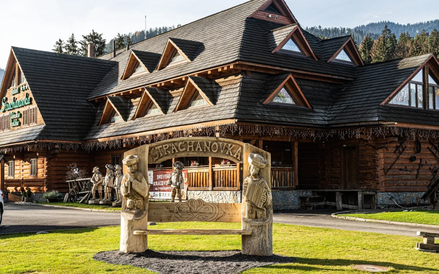 Hotel Strachanovka — Jánska koliba, drevené sochy a vchod do hotela